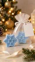 Vela artesanal em forma de floco de neve azul com saquinho de organza branco e laço de cetim