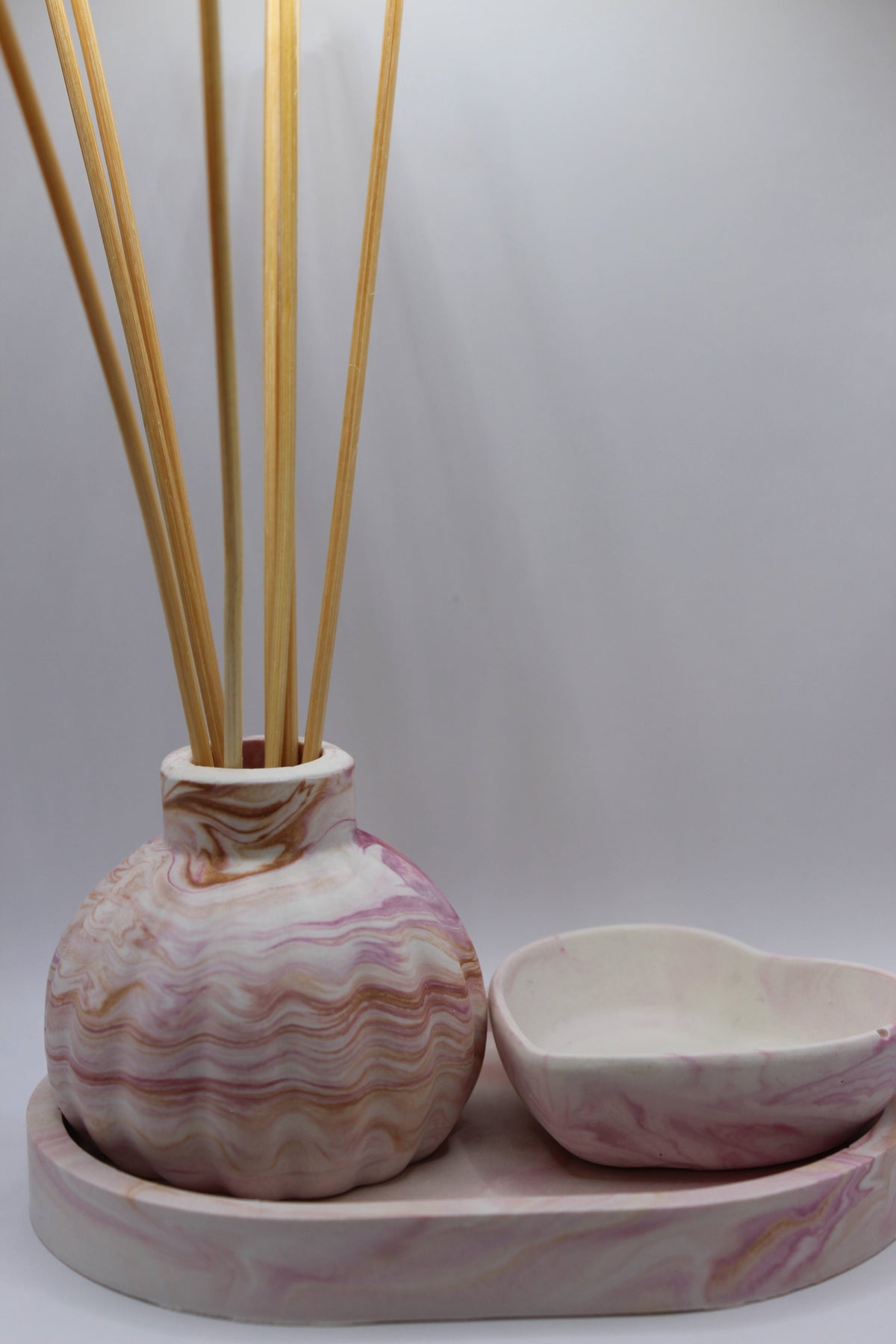Conjunto Aura — difusor e tigela em coração sobre tabuleiro de gesso rosa